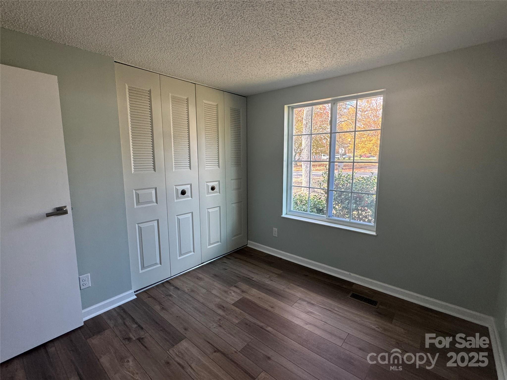 7939 Holly Hill Road Charlotte, NC 28227 - Photo 20 of 38 a view of an empty room with wooden floor and a window
