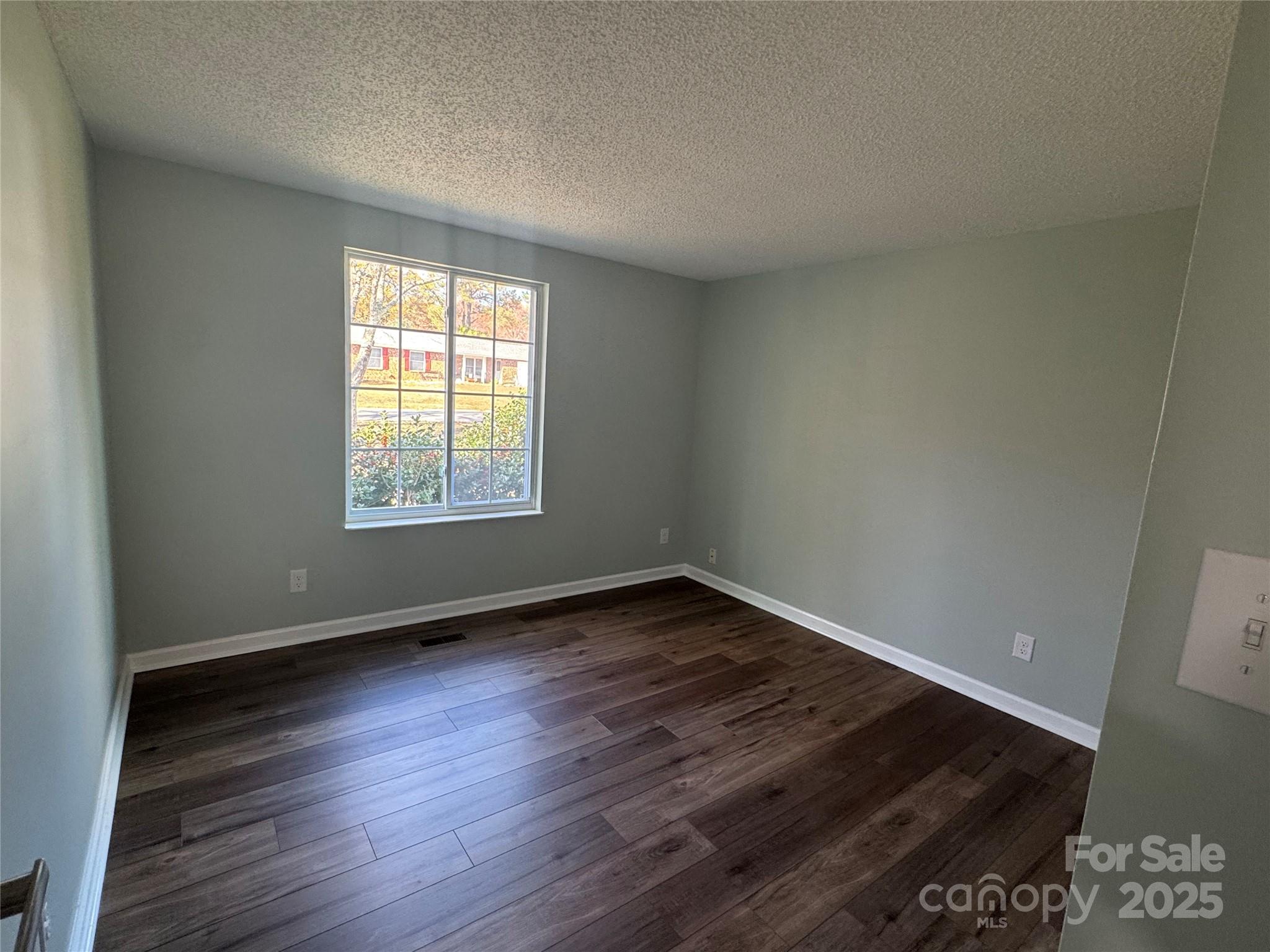 7939 Holly Hill Road Charlotte, NC 28227 - Photo 21 of 38 a view of an empty room with wooden floor and a window