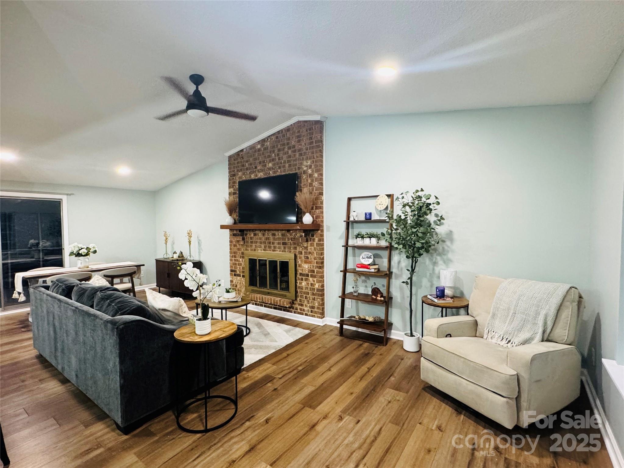 7939 Holly Hill Road Charlotte, NC 28227 - Photo 6 of 38 a living room with furniture a flat screen tv and a fireplace