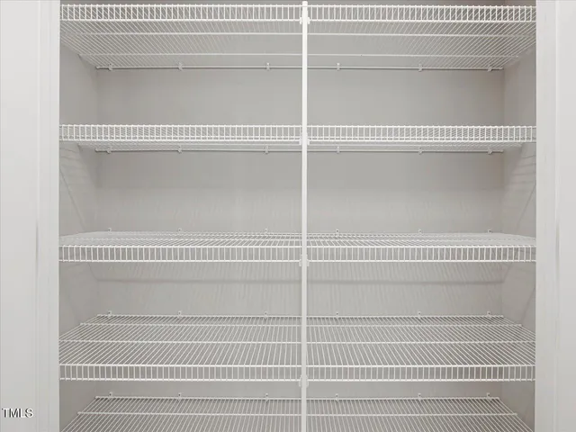 a view of an empty room with wooden floor and windows