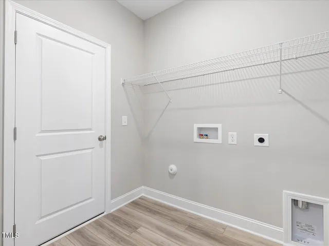 a view of hallway with window and a refrigerator