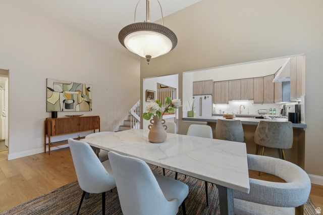 3674 Oak Rim Way Salt Lake City, UT 84109 - Photo 11 of 47 Dining area featuring vaulted ceilings, wood-finish flooring, and a contemporary light fixture