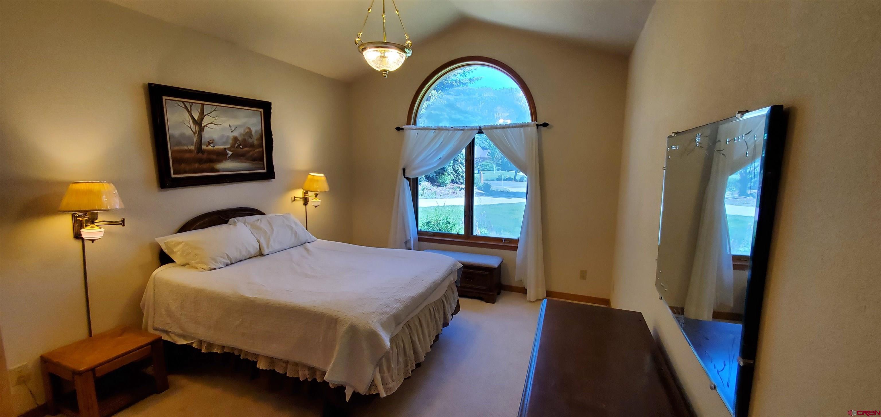 370 Red Rock Road Durango, CO 81301 - Photo 17 of 25 a bedroom with a bed a mirror on dresser and a window