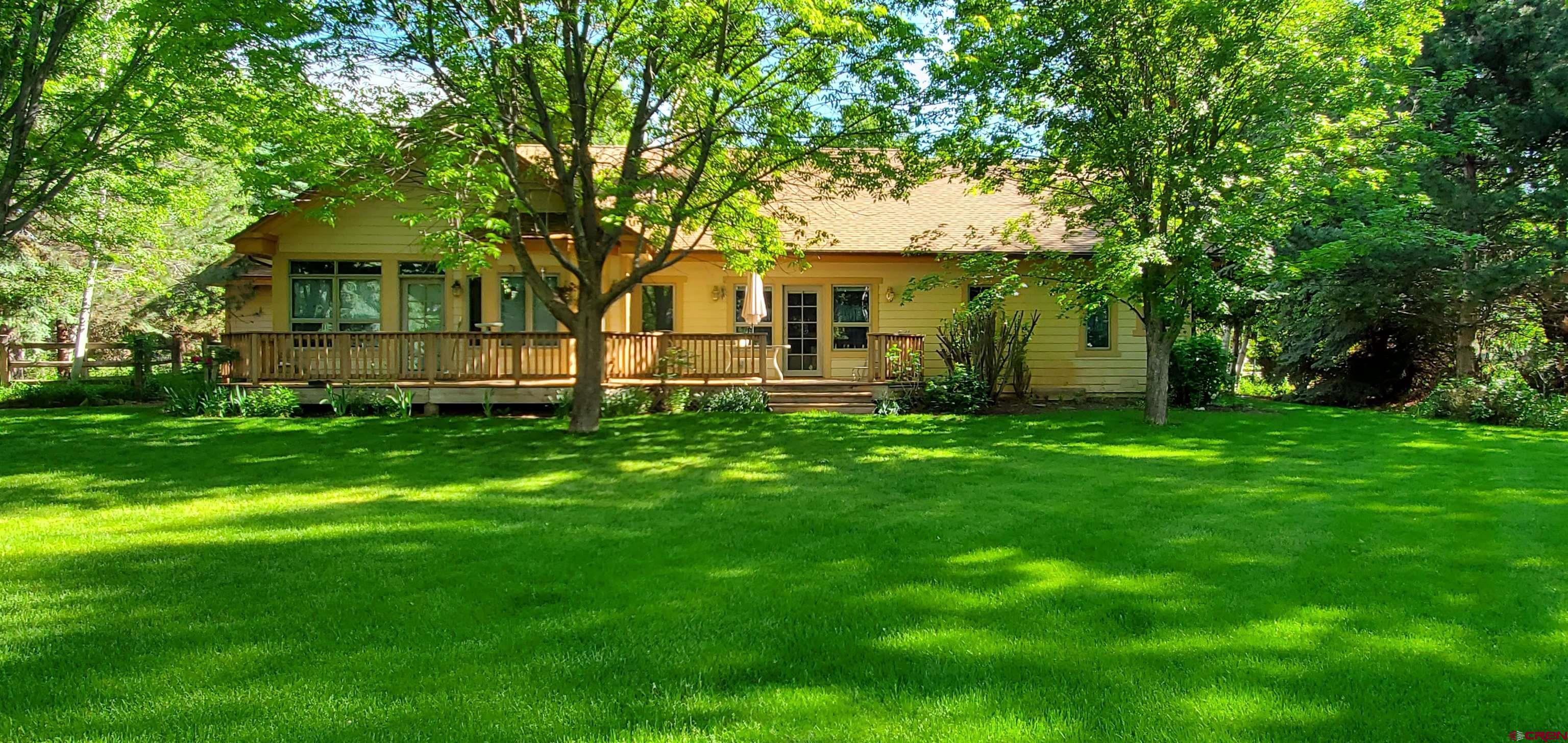 370 Red Rock Road Durango, CO 81301 - Photo 3 of 25 a front view of a house with a garden