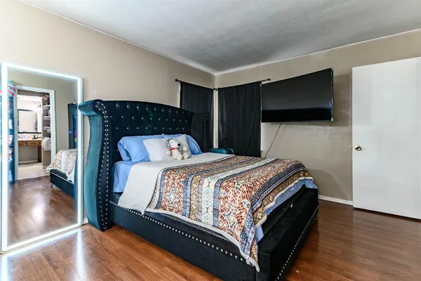 a bedroom with a bed and wooden floor