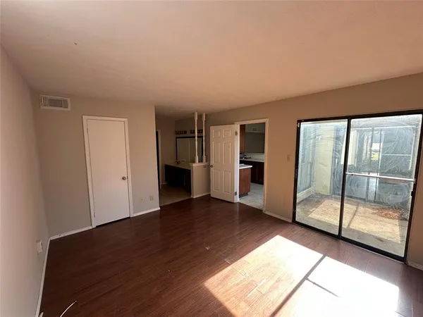 a view of empty room with wooden floor
