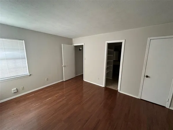 an empty room with wooden floor and closet