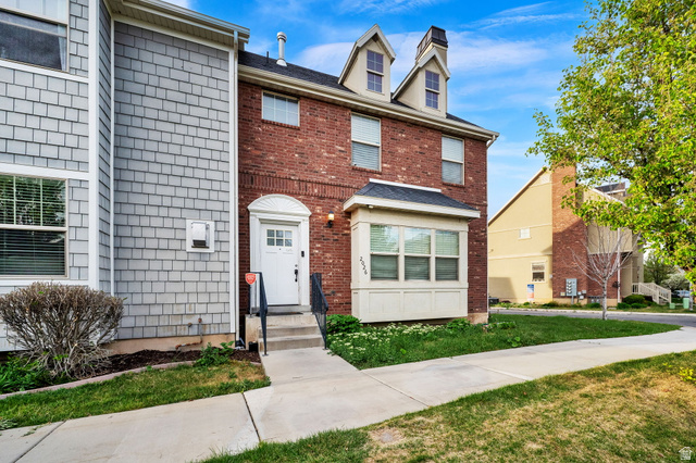View of front facade featuring a front lawn and brick siding