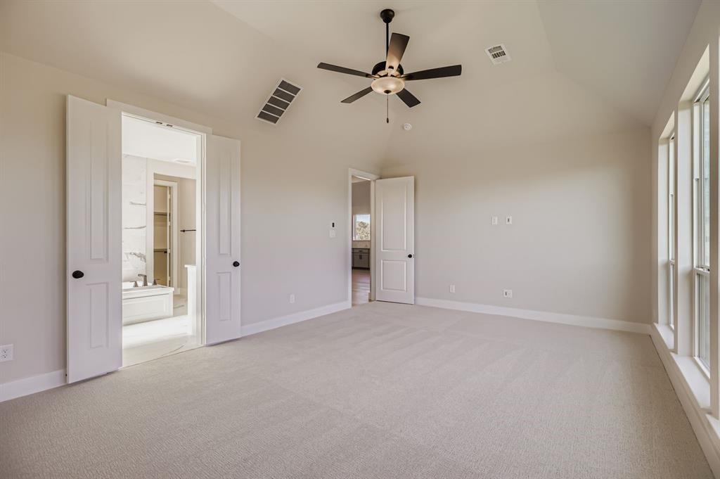 2118 Newhall Road Celina, TX 75009 - Photo 16 of 29 Unfurnished bedroom featuring lofted ceiling, light carpet, a ceiling fan, and ensuite bathroom