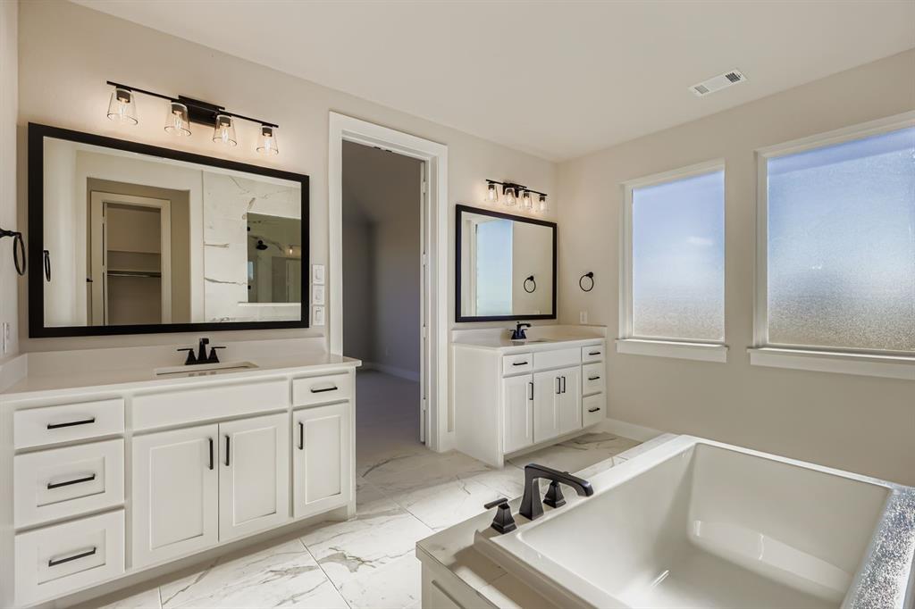 2118 Newhall Road Celina, TX 75009 - Photo 18 of 29 Bathroom with two vanities, light marble finish flooring, a stall shower, a garden tub, and a spacious closet