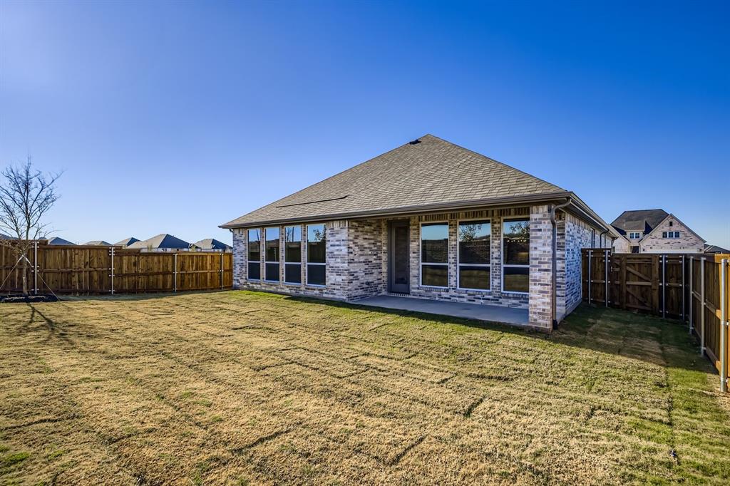 2118 Newhall Road Celina, TX 75009 - Photo 28 of 29 Rear view of house featuring brick siding, a patio, a fenced backyard, roof with shingles, and a gate