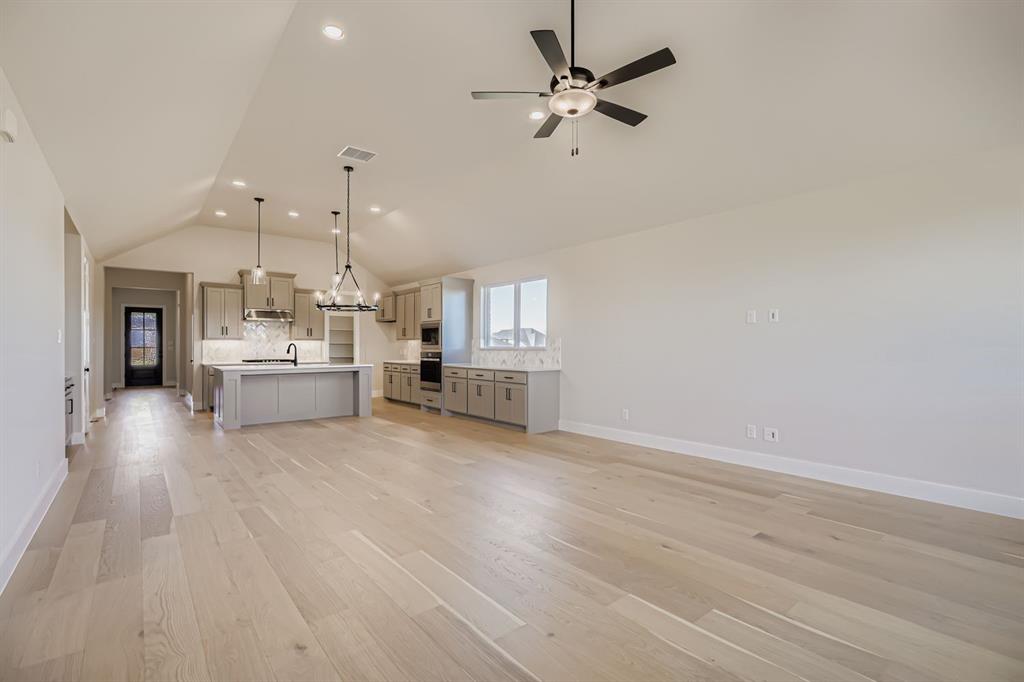 2118 Newhall Road Celina, TX 75009 - Photo 6 of 29 Unfurnished living room with vaulted ceiling, recessed lighting, light wood-style floors, and a ceiling fan
