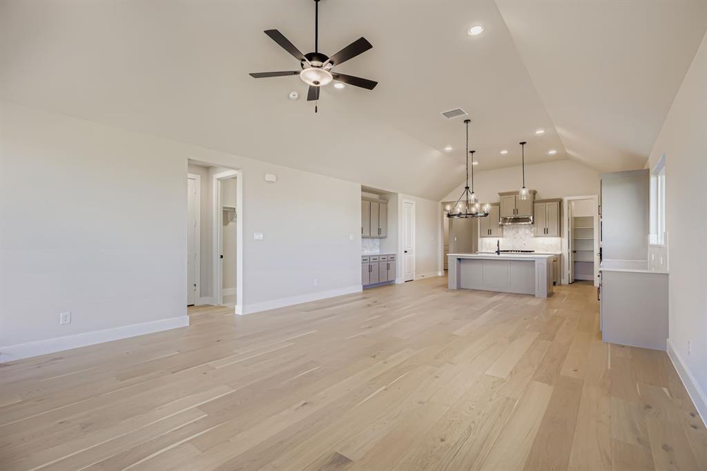 2118 Newhall Road Celina, TX 75009 - Photo 7 of 29 Unfurnished living room featuring a chandelier, light wood-style floors, lofted ceiling, ceiling fan, and recessed lighting