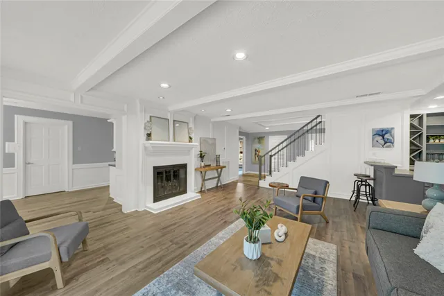 a living room with furniture fireplace and wooden floor