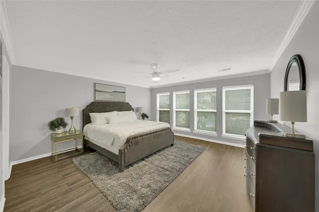 a spacious bedroom with a bed and wooden floor