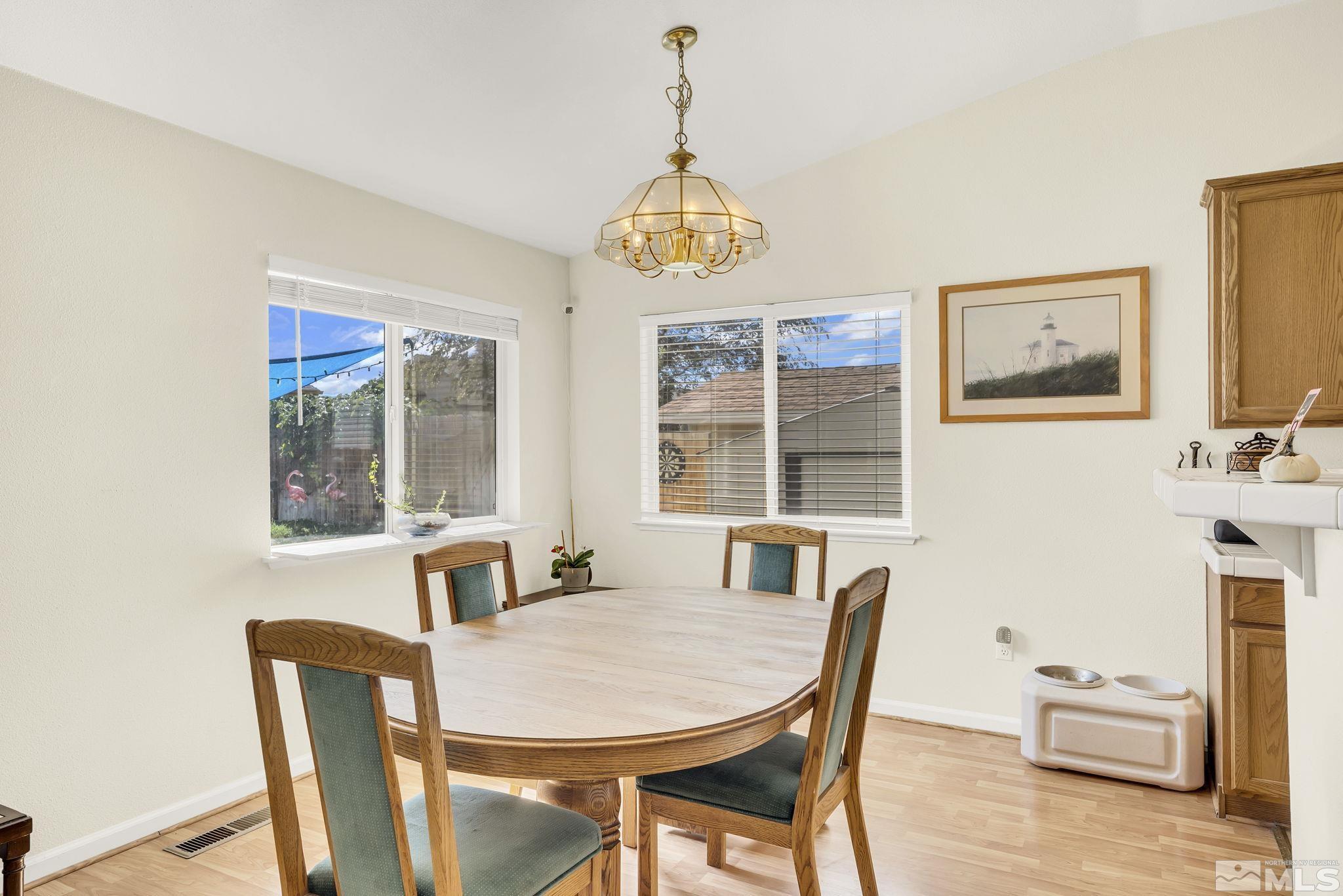 407 Sunshine Lane Fernley, NV 89408 - Photo 13 of 26 a view of a dining room with furniture wooden floor and a chandelier