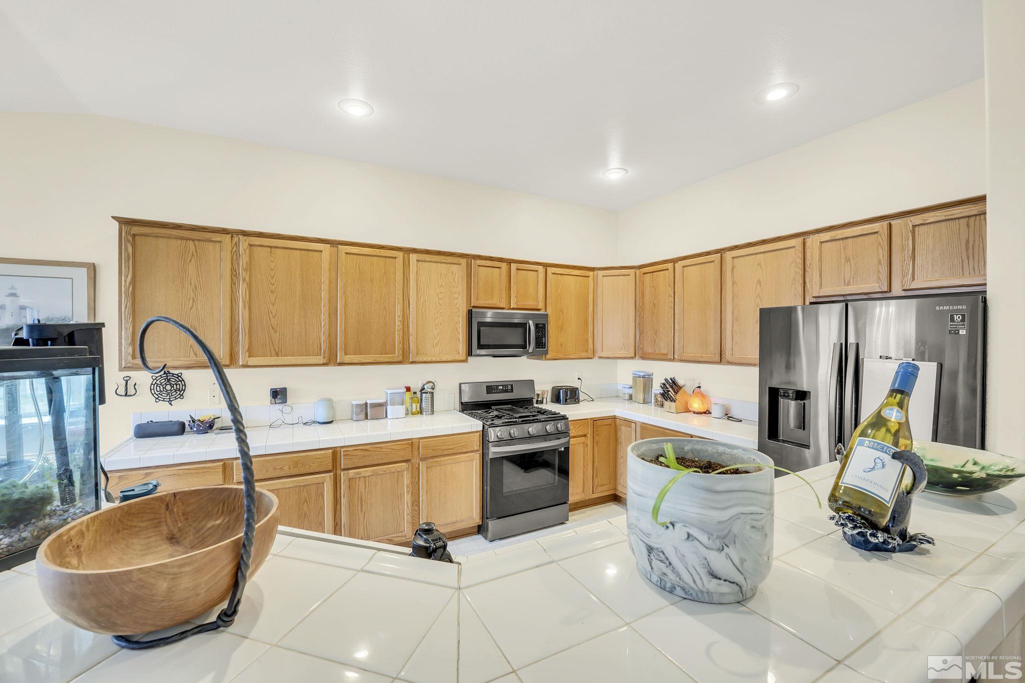 407 Sunshine Lane Fernley, NV 89408 - Photo 15 of 26 a kitchen with stainless steel appliances granite countertop a sink dishwasher stove top oven a refrigerator and cabinets with wooden floor