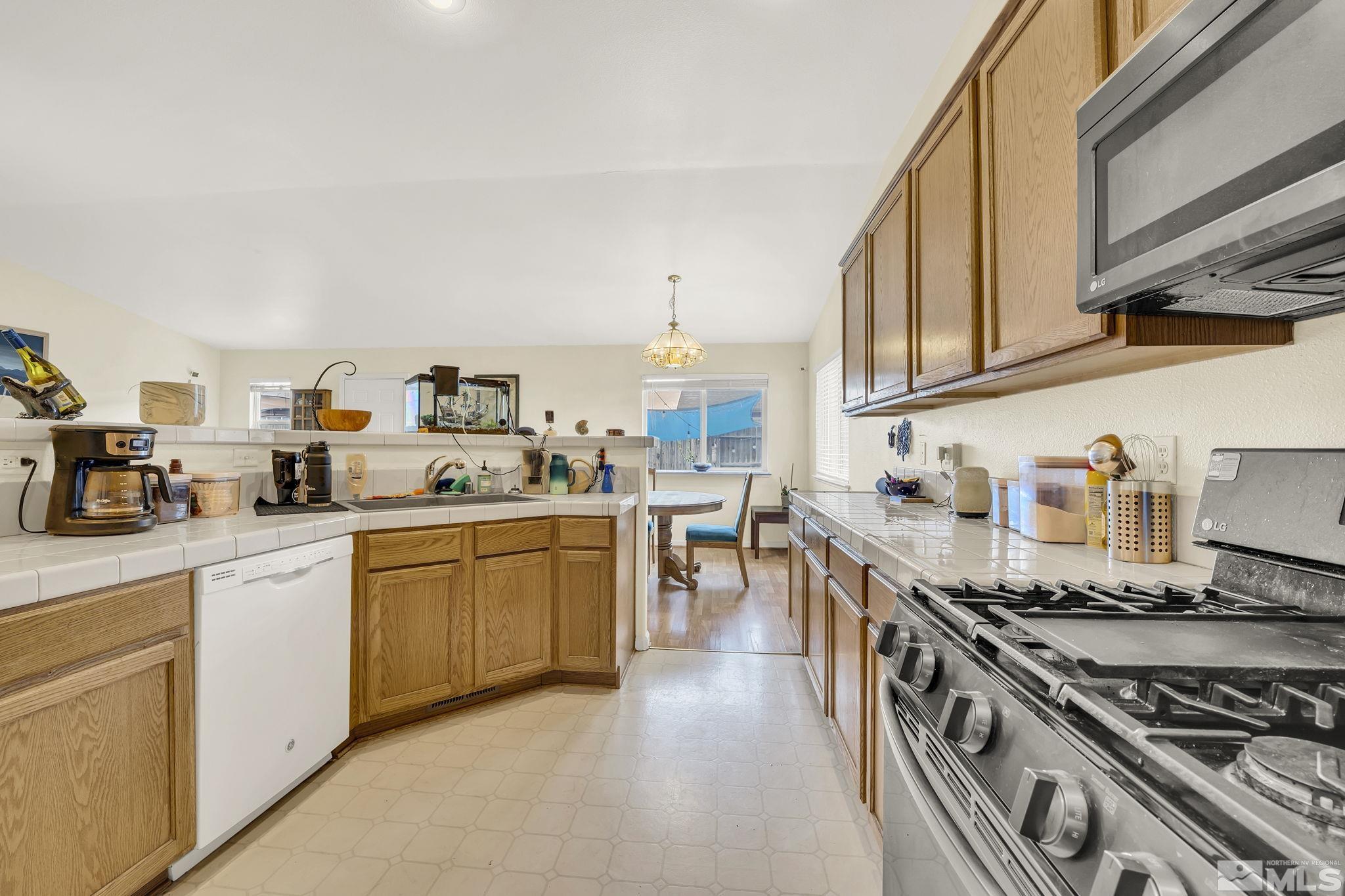 407 Sunshine Lane Fernley, NV 89408 - Photo 16 of 26 a kitchen with stove a sink and cabinets