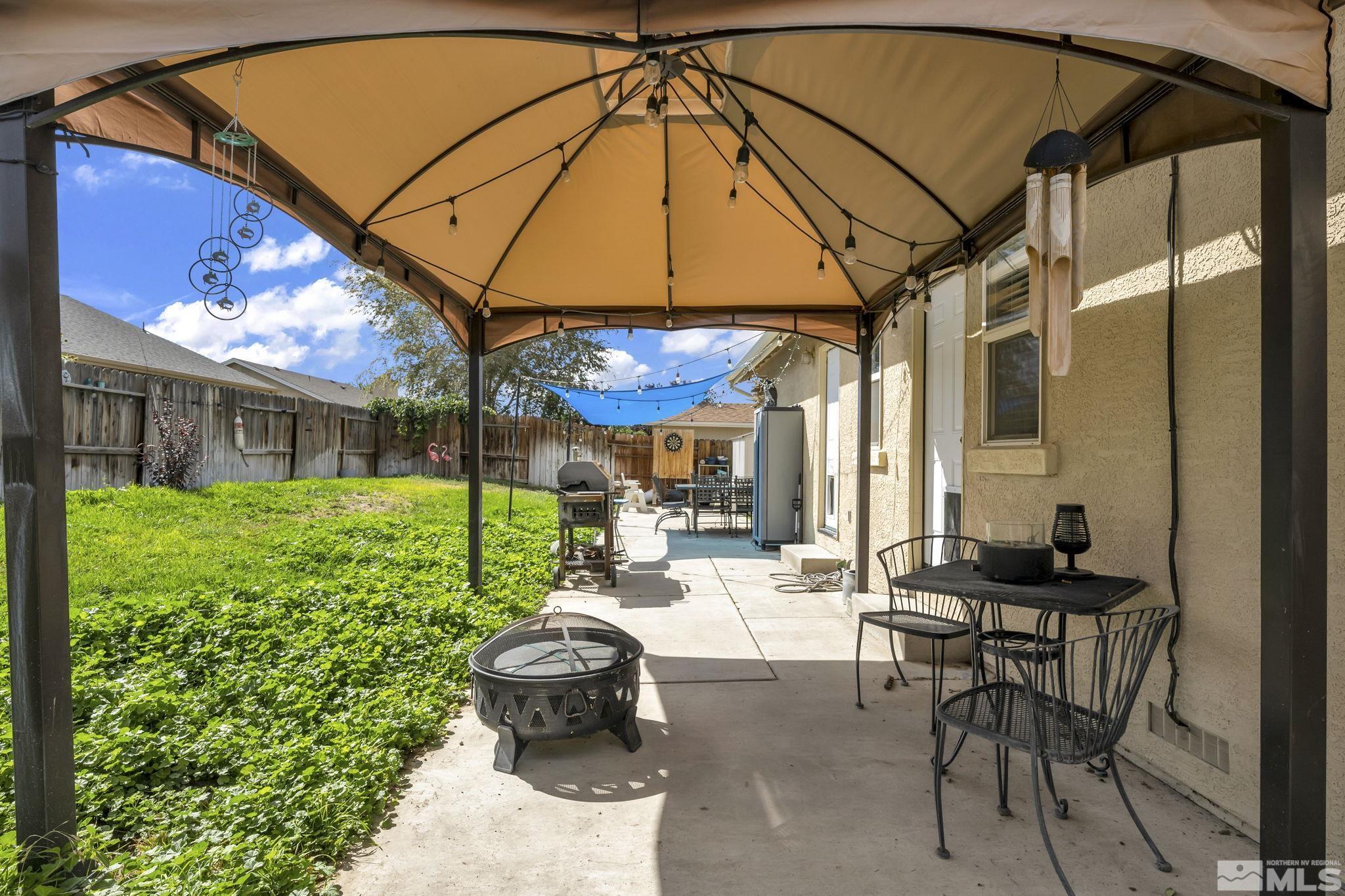 407 Sunshine Lane Fernley, NV 89408 - Photo 24 of 26 a view of a patio with table and chairs under an umbrella