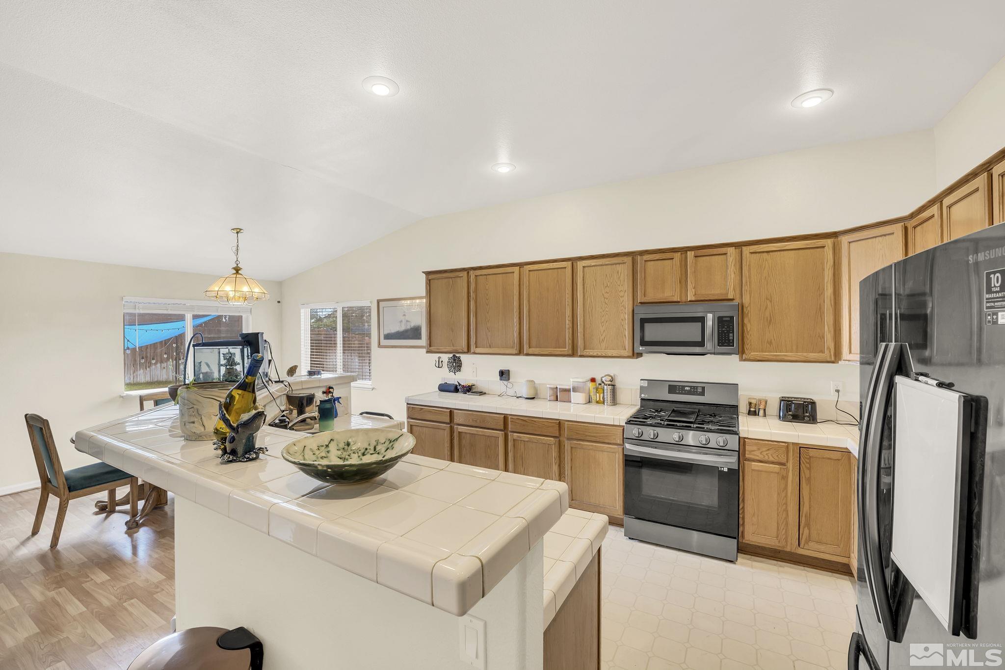 407 Sunshine Lane Fernley, NV 89408 - Photo 10 of 26 a kitchen with stainless steel appliances a stove refrigerator sink and microwave