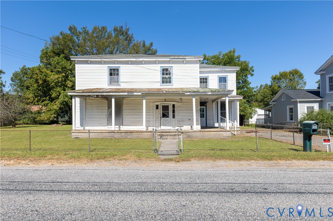 13512 Queen Street Disputanta, VA 23842 - Photo 1 of 46 a front view of a house with a garden and porch