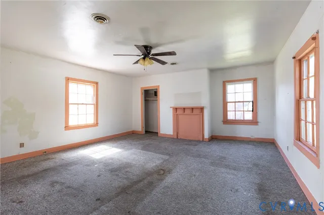 en empty room with windows and fan