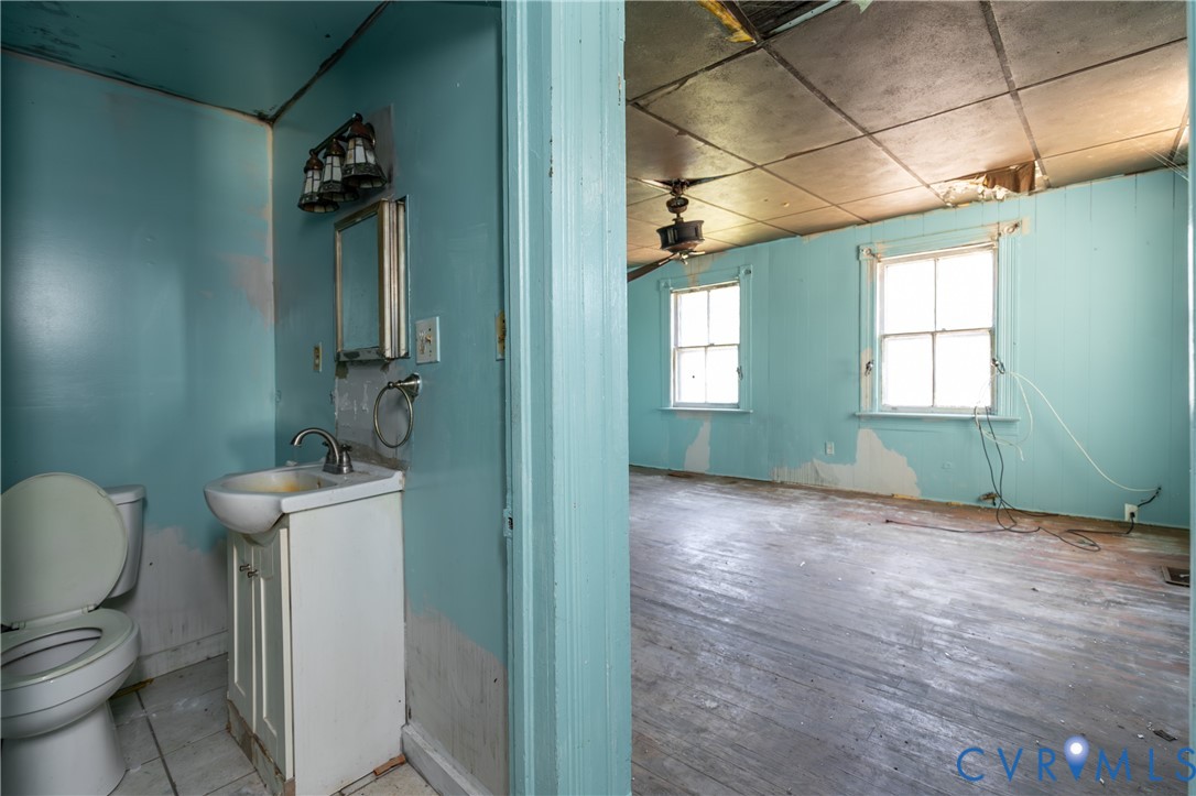 13512 Queen Street Disputanta, VA 23842 - Photo 8 of 46 a bathroom with a toilet a sink and mirror