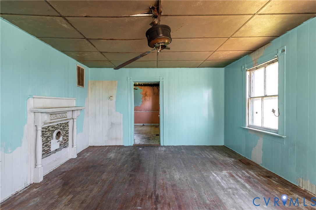 13512 Queen Street Disputanta, VA 23842 - Photo 10 of 46 a view of empty room with a fireplace and wooden floor