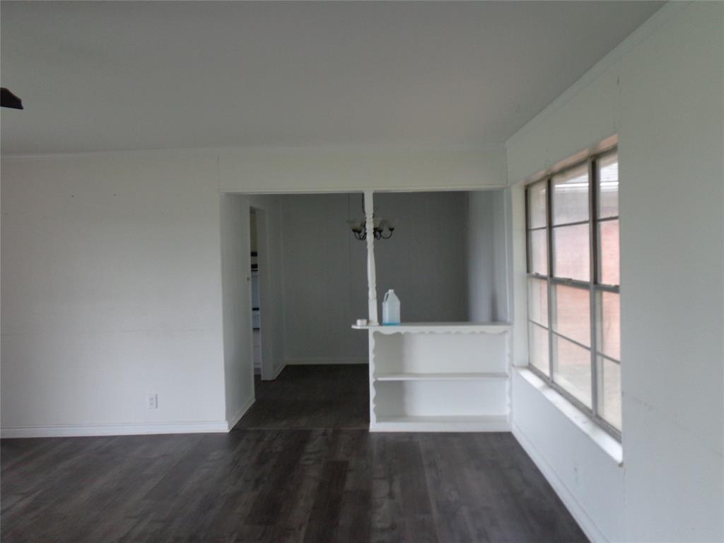 612 South Files Street Itasca, TX 76055 - Photo 16 of 30 Empty room featuring dark wood-style floors and crown molding