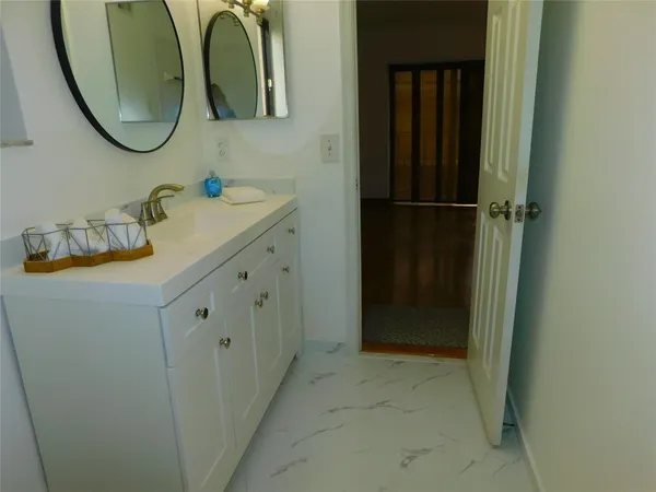 a bathroom with a granite countertop sink and a mirror