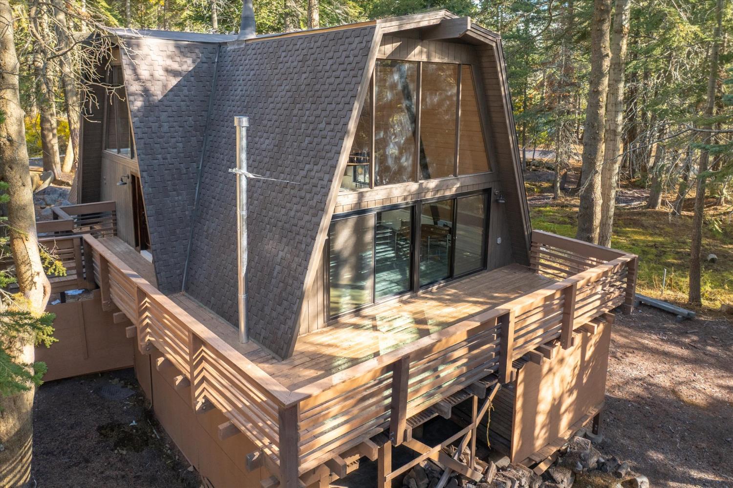 278 Monty Wolf Road Bear Valley, CA 95223 - Photo 1 of 1 a backyard of a house with large trees and outdoor seating