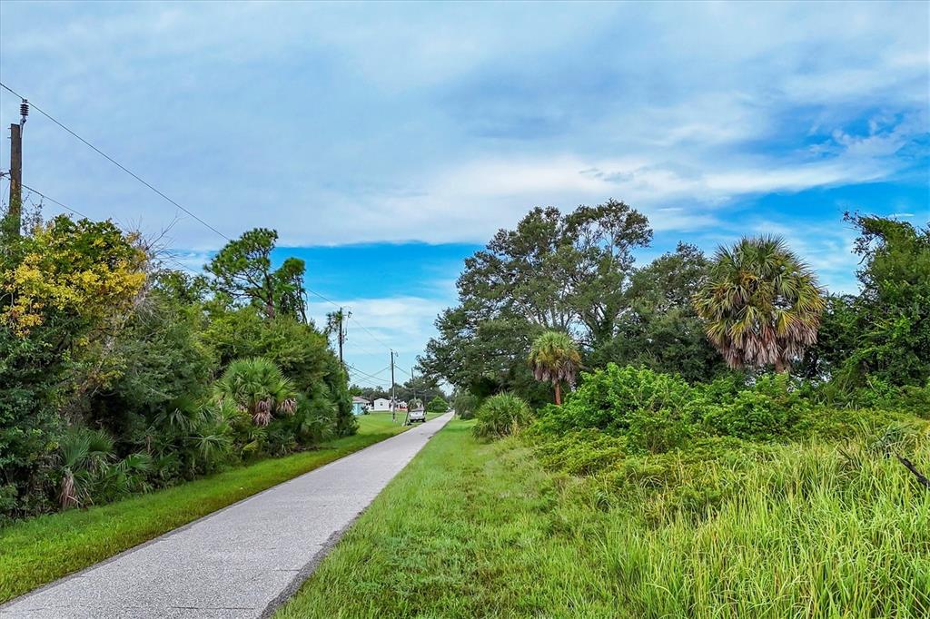 3285 South Access Road Englewood, FL 34224 - Photo 12 of 20 a view of a yard with flower plants and wooden fence