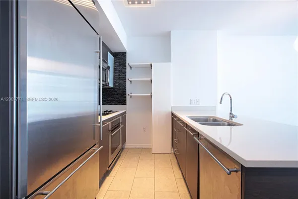 a kitchen with a sink and stainless steel appliances