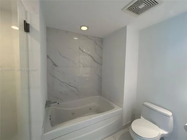a bathroom with a toilet and bathtub