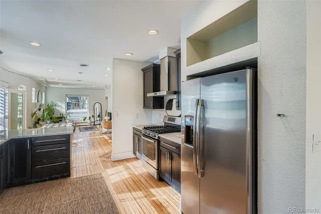 a kitchen with stainless steel appliances granite countertop a refrigerator and a stove top oven