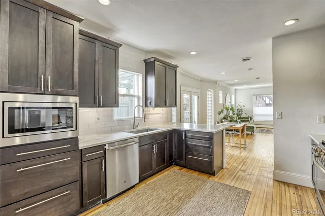 a kitchen with stainless steel appliances granite countertop a stove a sink and a microwave