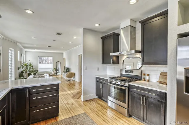 a kitchen with stainless steel appliances granite countertop a stove a sink and a refrigerator