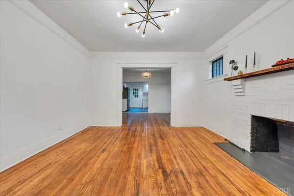a view of a room with wooden floor and a ceiling fan