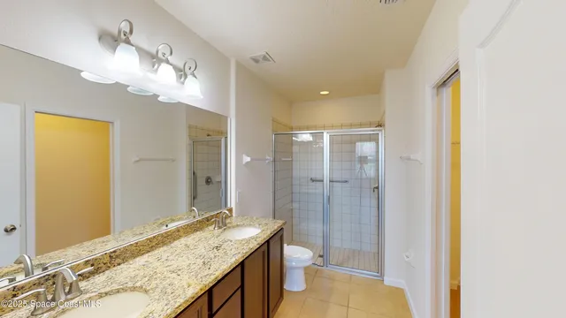 a bathroom with a granite countertop sink a mirror and a shower