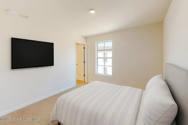 a bedroom with a flat screen tv and a window