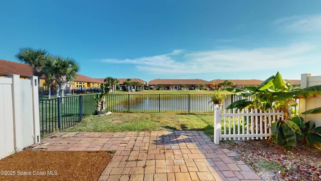 a view of a lake with a floor to ceiling window next to a yard