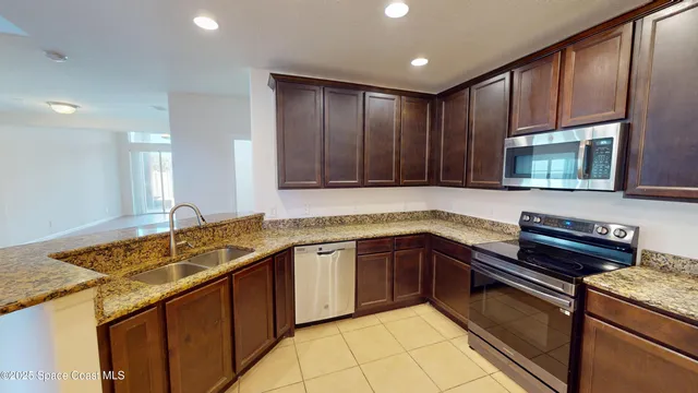 a kitchen with stainless steel appliances granite countertop wooden cabinets a sink and dishwasher