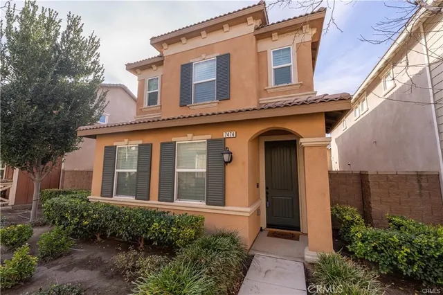 a front view of a house with plants and entryway