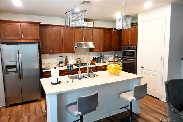 a kitchen with a sink a stove and chairs