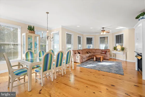 a kitchen with stainless steel appliances kitchen island granite countertop a refrigerator a stove and white cabinets with wooden floor