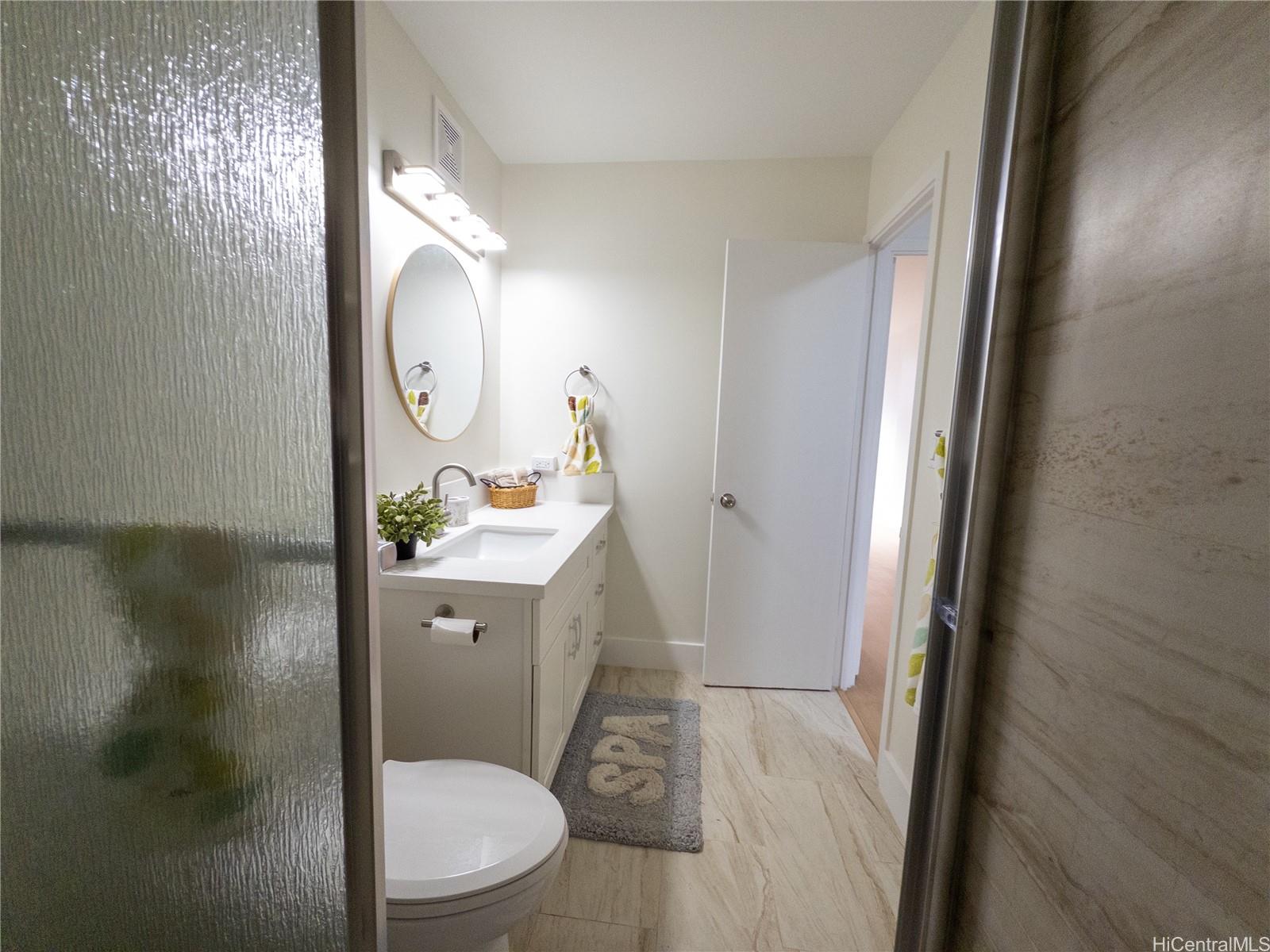 425 Ena Road, Unit 607C Honolulu, HI 96815 - Photo 10 of 21 a bathroom with a toilet a sink and mirror