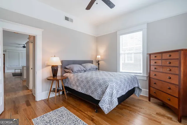 a bedroom with a bed and wooden floor