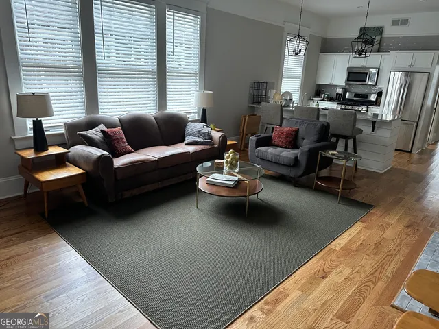 a living room with furniture a flat screen tv and a large window
