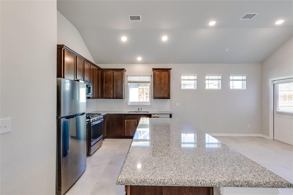 325 Diamondleaf Drive Buda, TX 78610 - Photo 9 of 29 a large kitchen with stainless steel appliances granite countertop a stove refrigerator and cabinets
