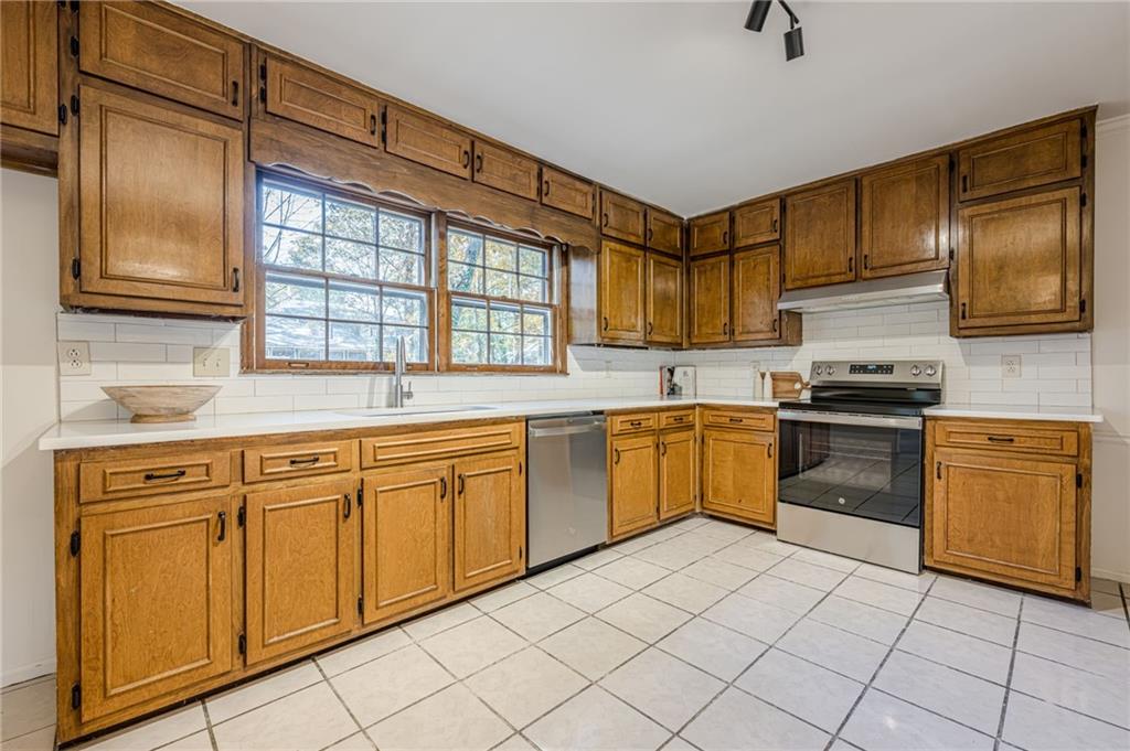 4147 Scofield Place Stone Mountain, GA 30083 - Photo 17 of 56 a kitchen with granite countertop cabinets stainless steel appliances and a sink